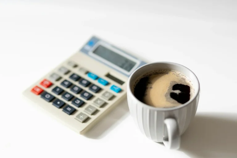 Ce inseamna sold cu minus a cup of coffee next to a calculator