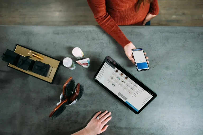 Ce inseamna suma debitata person holding smartphone beside tablet computer