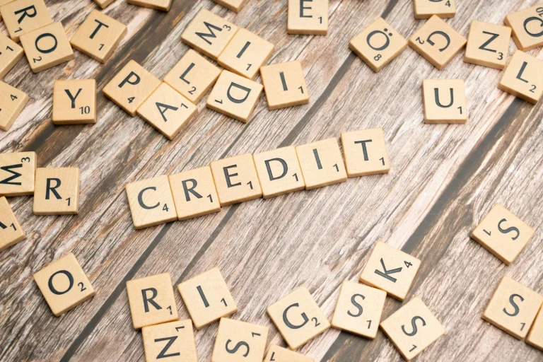 Ce inseamna asigurare de credit scrabbled letters spelling credit on a wooden surface
